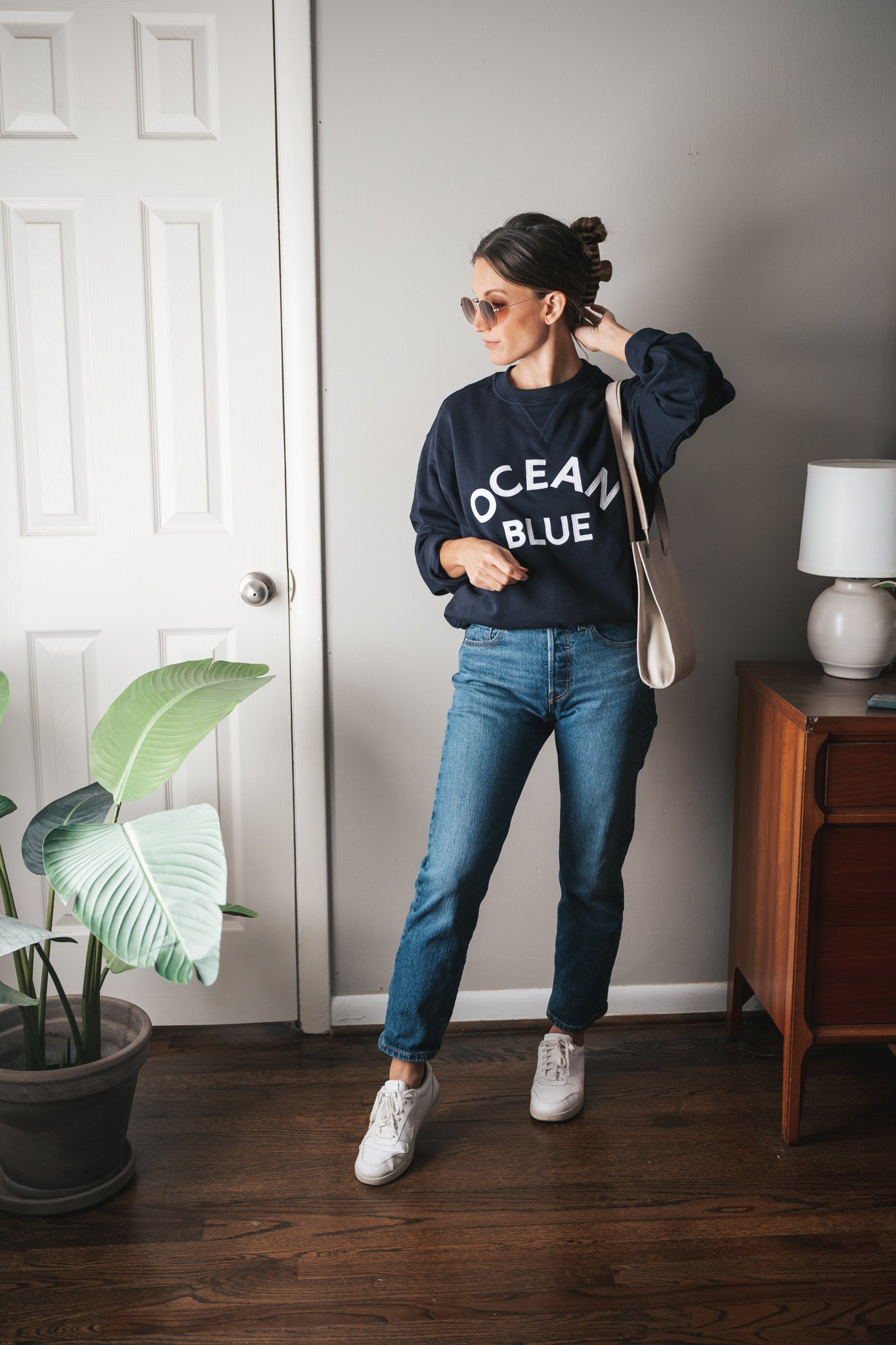 weekend outfit with a navy graphic tee, dark wash denim, and white sneakers