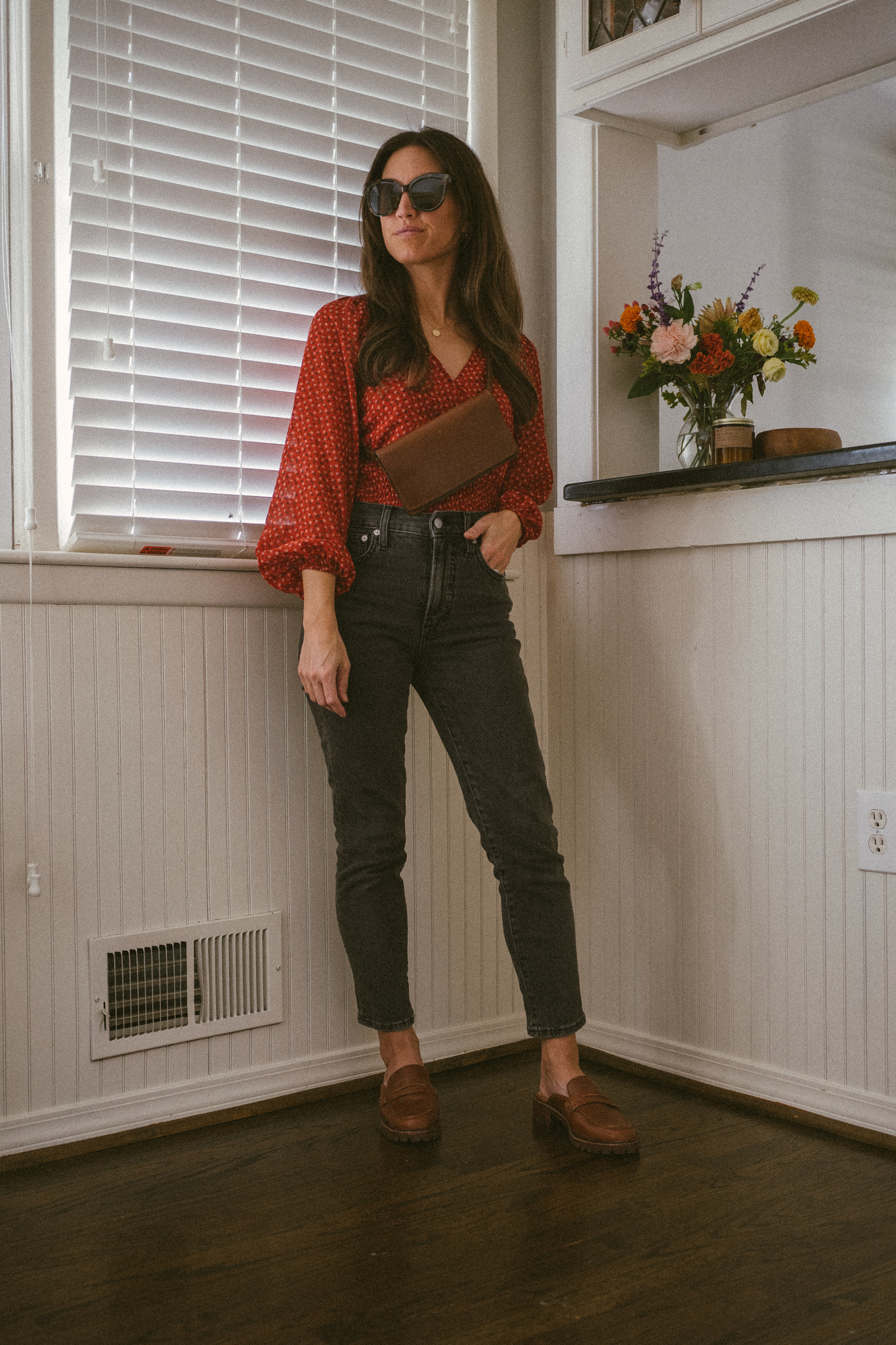 fall outfit idea with a red floral blouse, black denim, and brown loafer mules