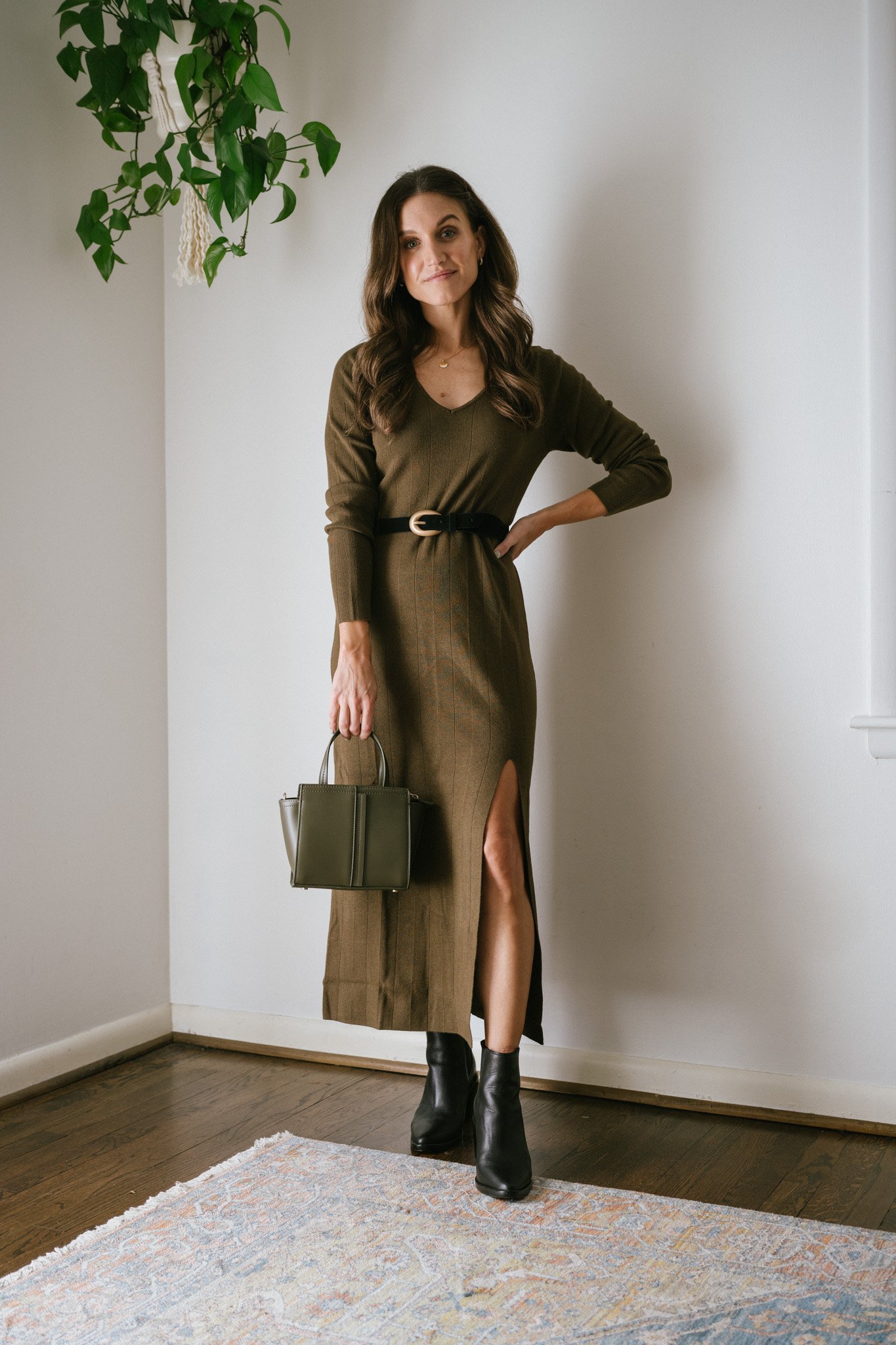 thanksgiving outfit idea with an olive green dress, black ankle boots, black belt with a gold clasp, and a green handbag