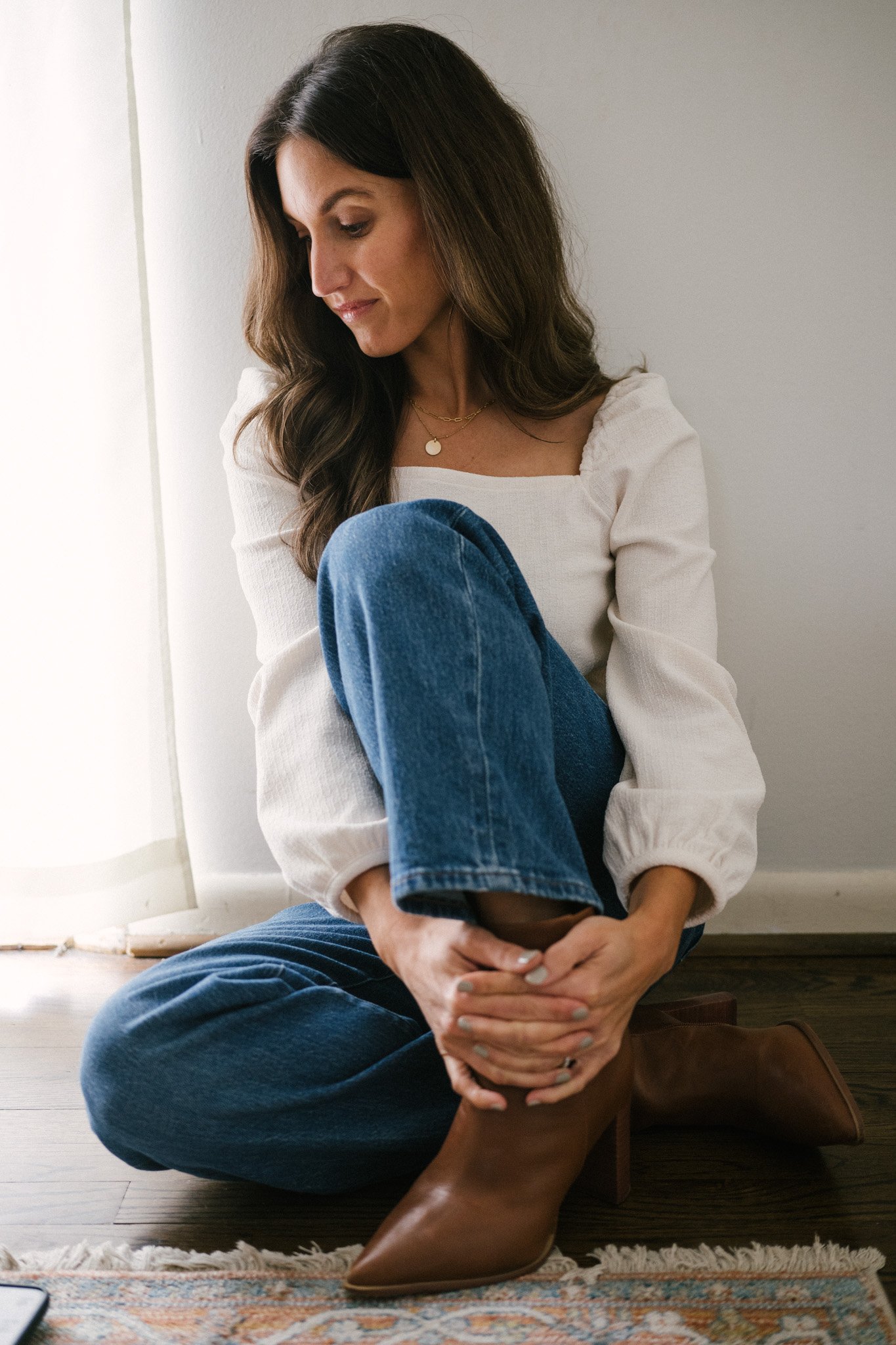 daily look featuring a white puff sleeve top, wide leg jeans with a brown belt, brown heeled ankle boots, and a gray shoulder bag