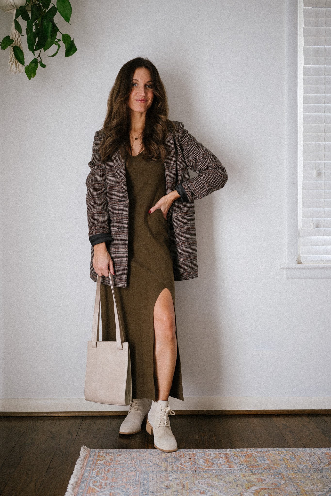 ashley wearing a green knit midi dress, plaid blazer, and light gray ankle boots