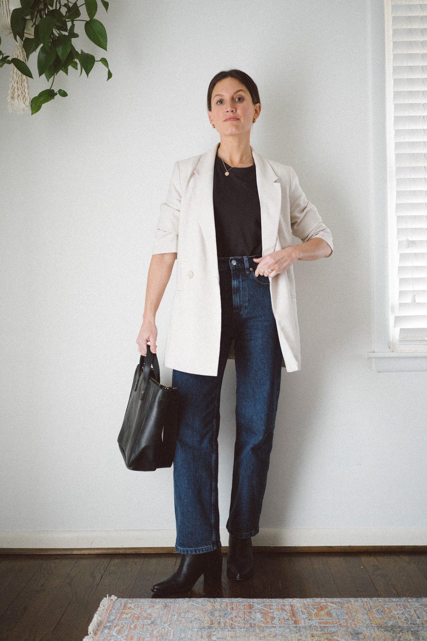 casual chic outfit with a black tee, ivory blazer, dark wash straight denim, black booties, and a black tote bag