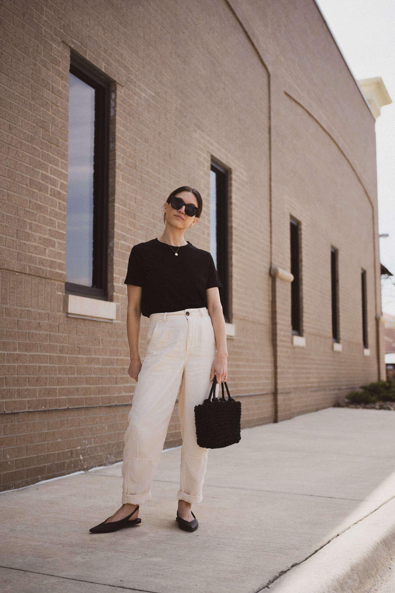 neutral spring outfit idea with a black tee, beige pants, and black slingback flats