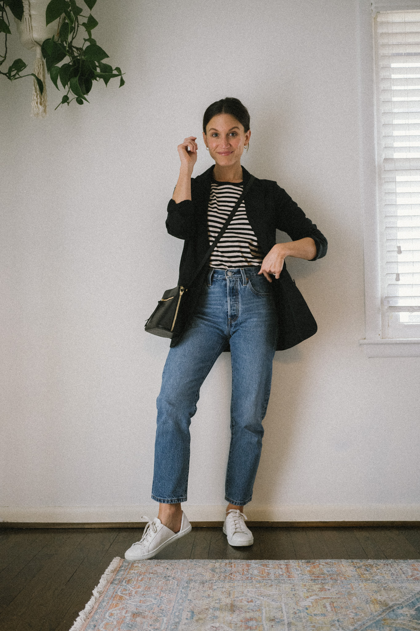 spring outfit idea with a striped tee, black blazer, medium wash denim, and white sneakers