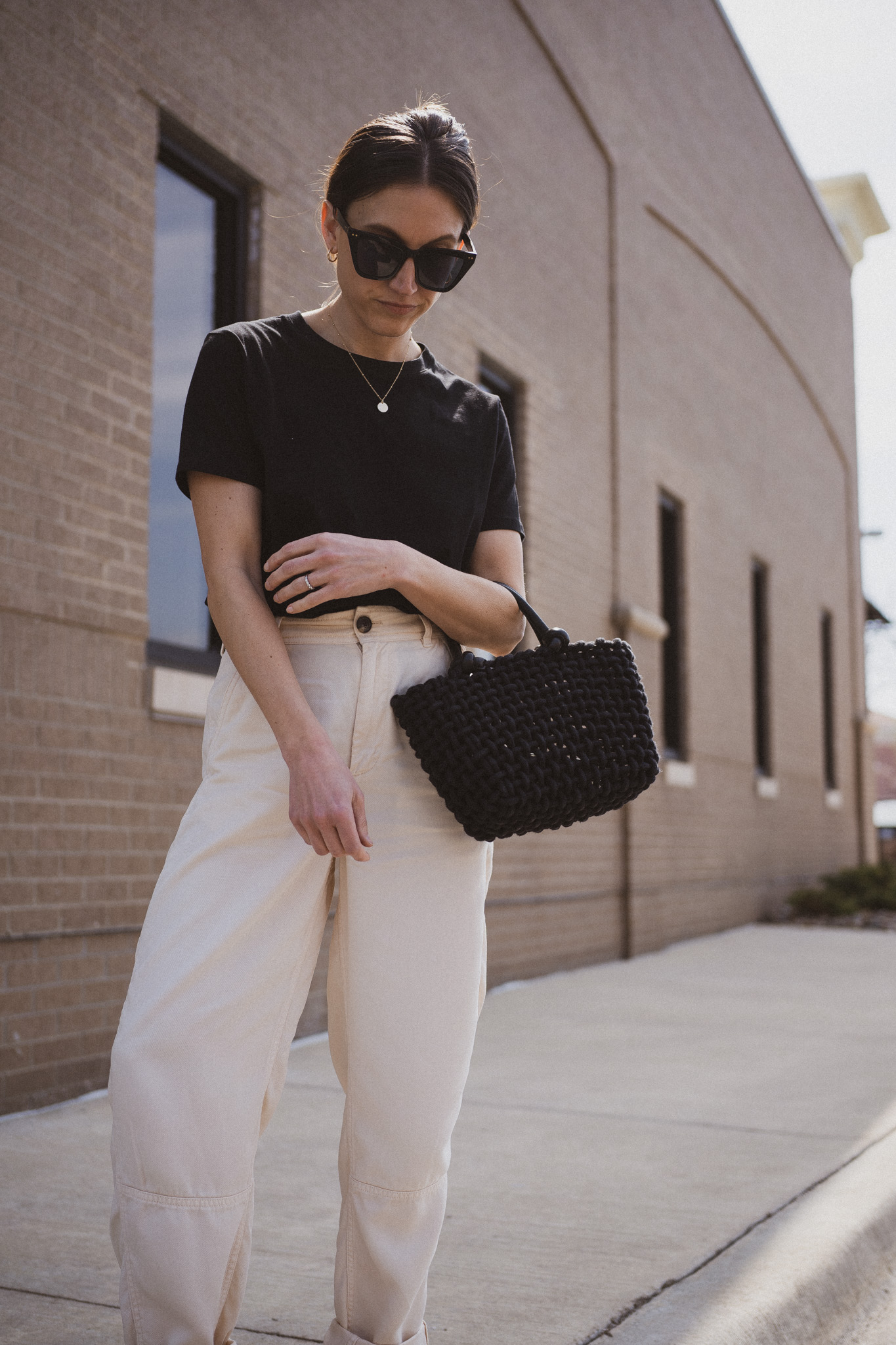 neutral spring outfit idea with a black tee, beige pants, and black slingback flats