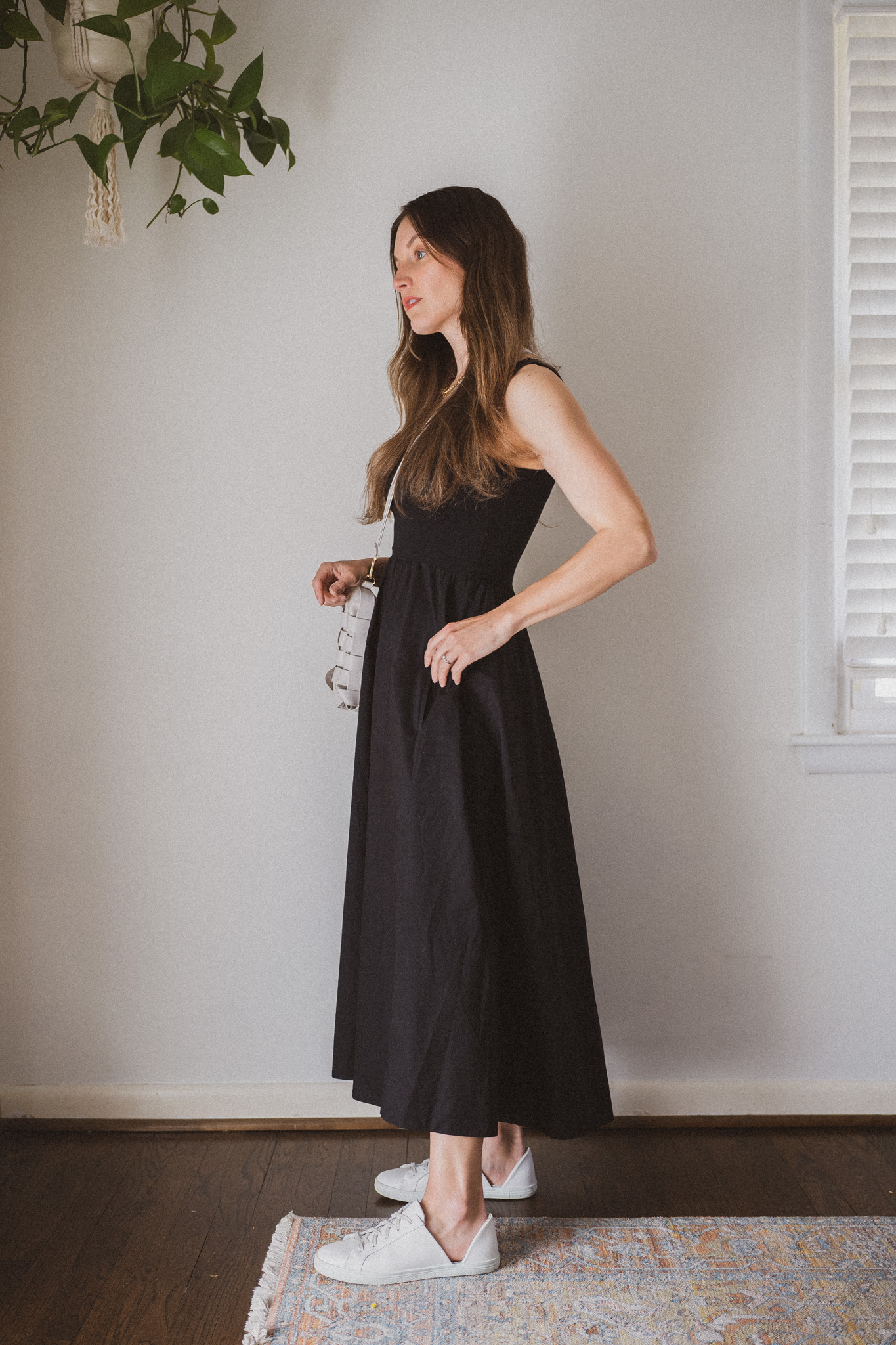 spring outfit with a black a-line midi dress and white sneakers