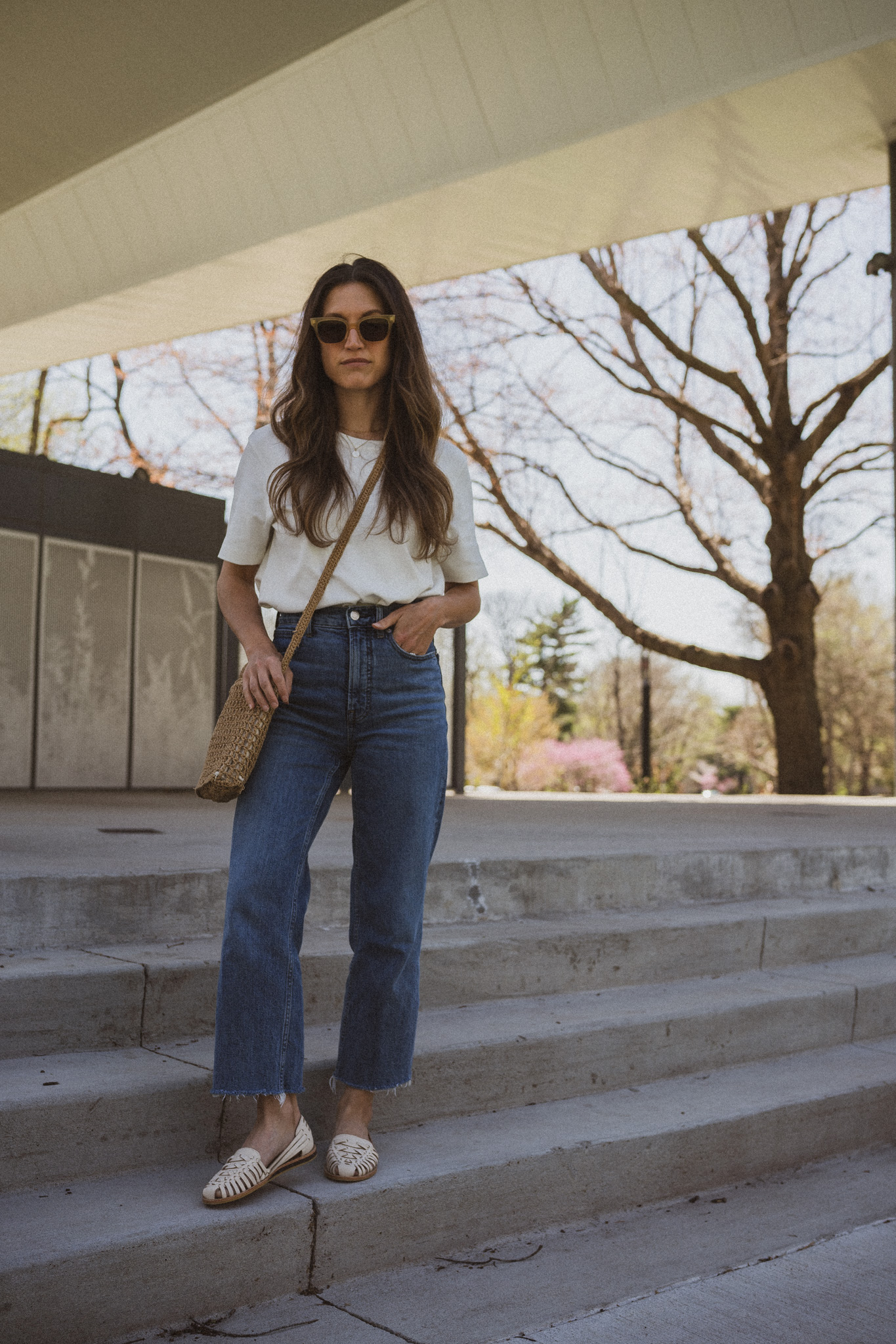 spring outfit idea with a white tee, medium wash denim, and huarache sandals