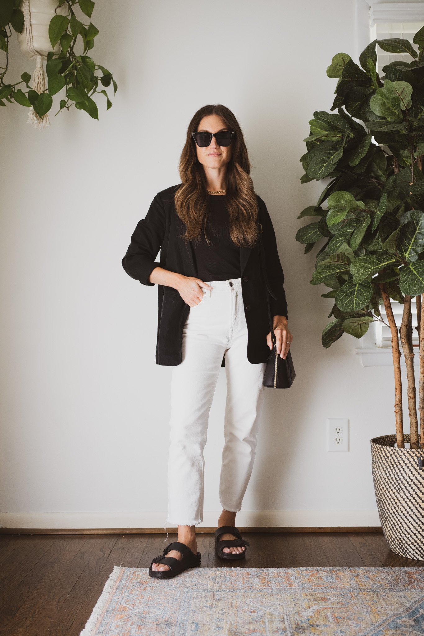 minimal outfit with a black tank, black blazer, white denim, and black Birkenstock sandals