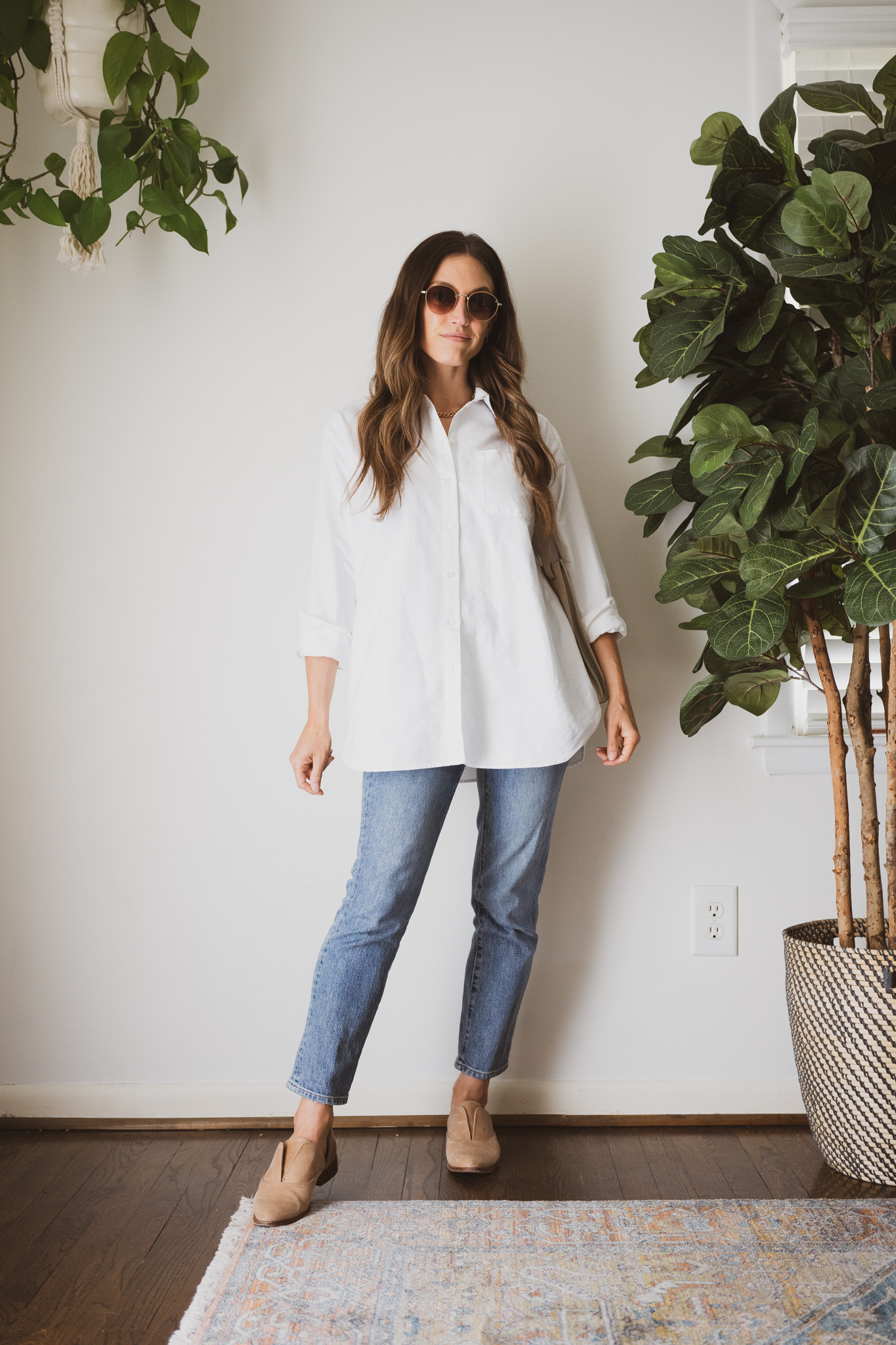 minimalist outfit with an oversized white button down, slim cut medium wash denim, and tan Oxfords