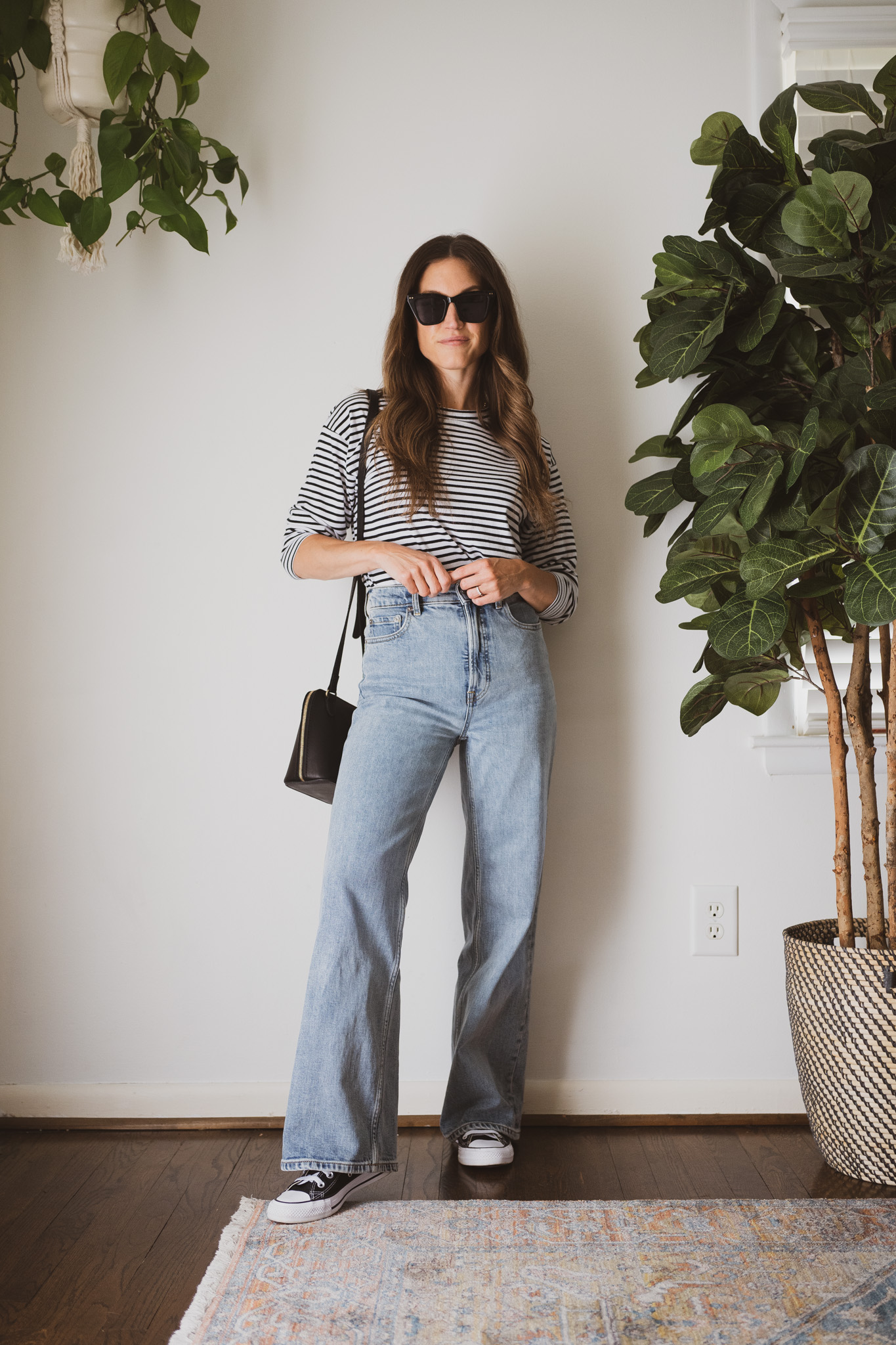 minimal outfit with a striped tee, wide leg denim, and high top converse