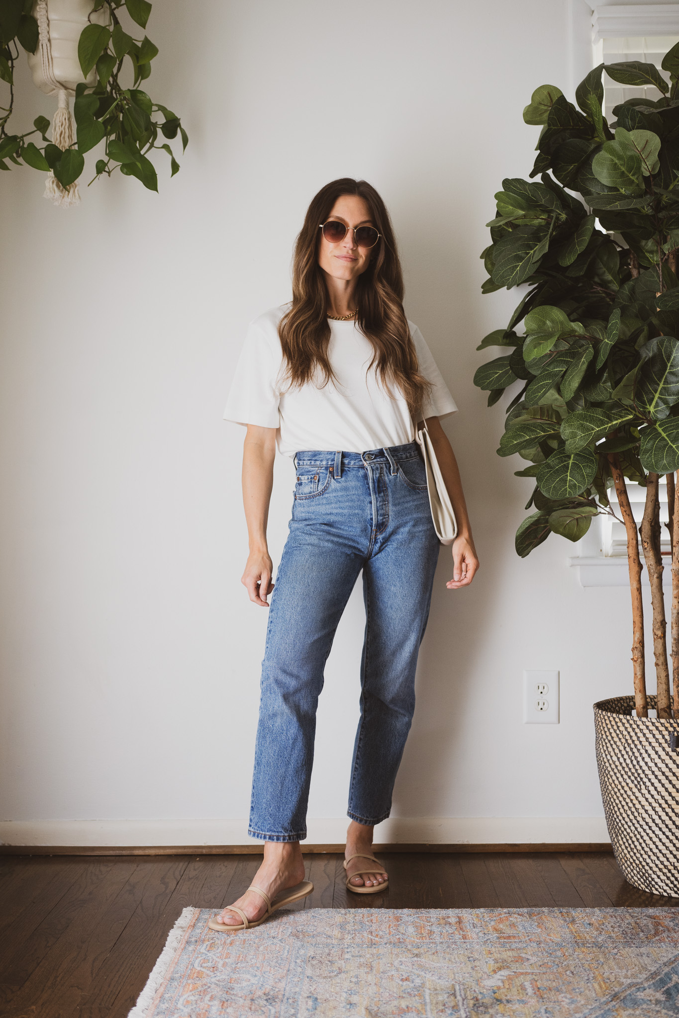 minimal outfit with a white tee, denim, nude sandals, and round sunglasses