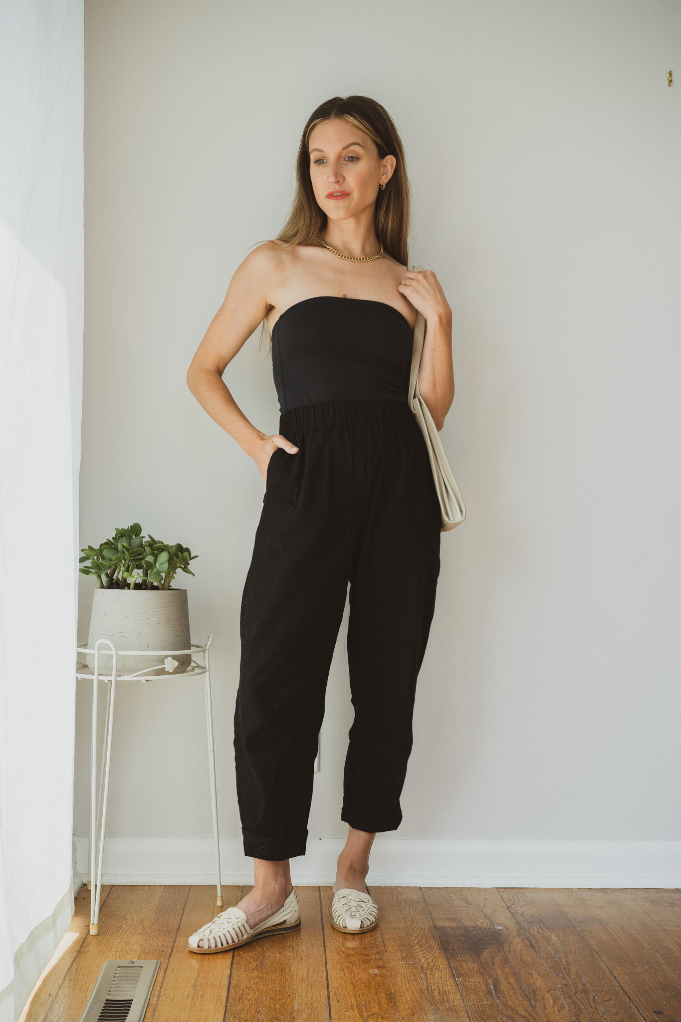 minimal outfit idea with a black tube top, black relaxed pants, and huarache sandals