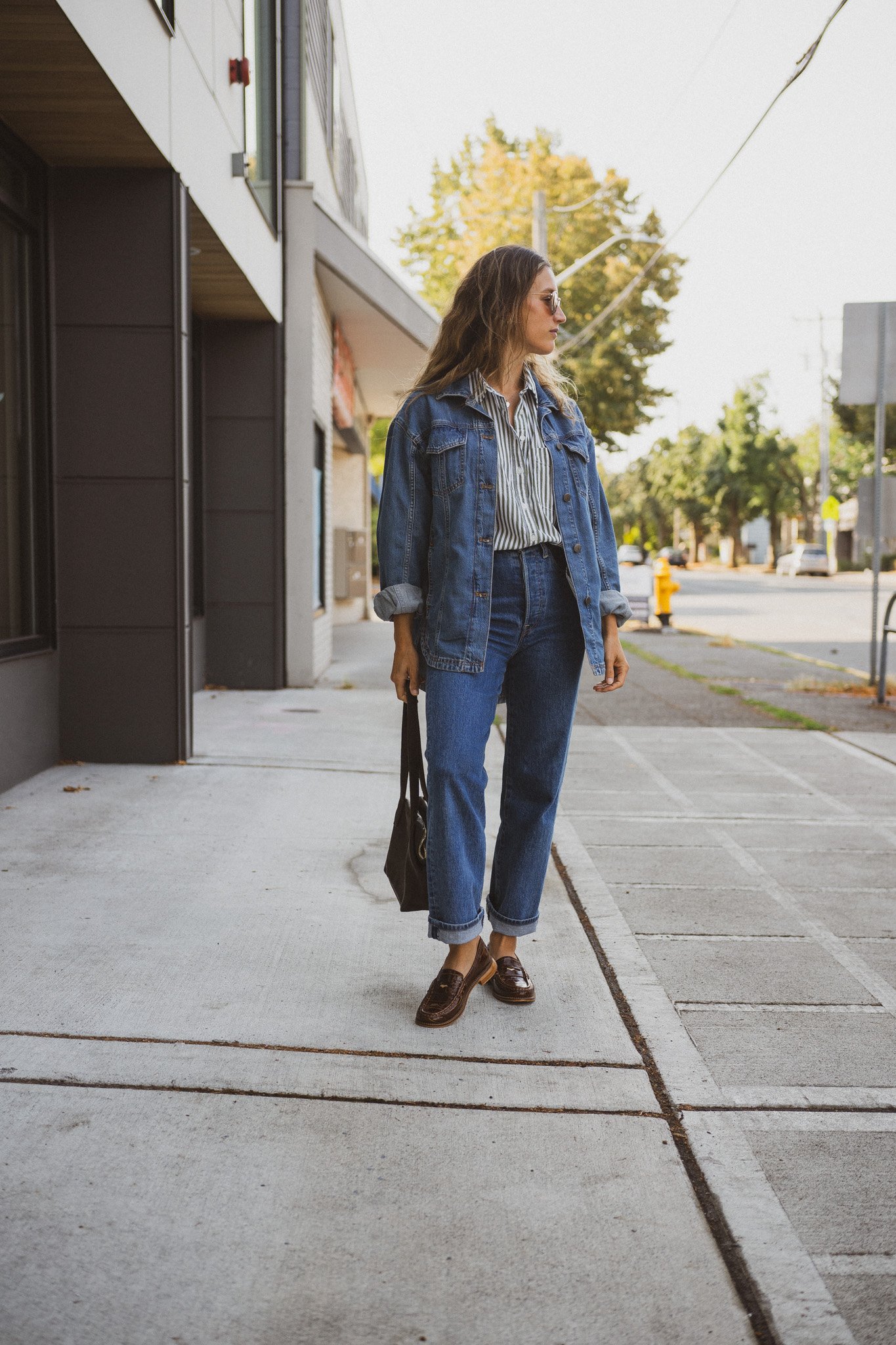 fall outfit idea with a striped button down, denim shirt jacket, medium wash denim, and brown loafers