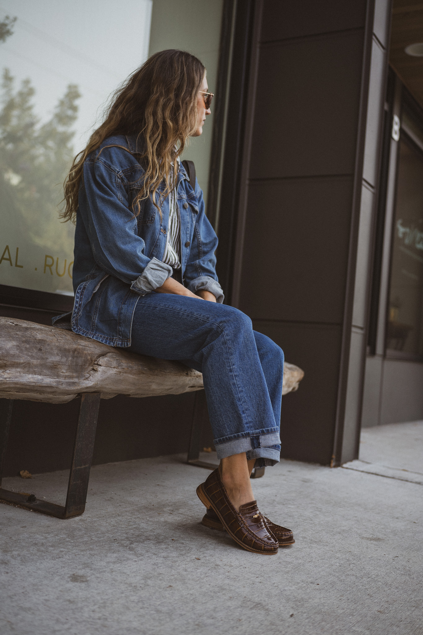 fall outfit idea with a striped button down, denim shirt jacket, medium wash denim, and brown loafers