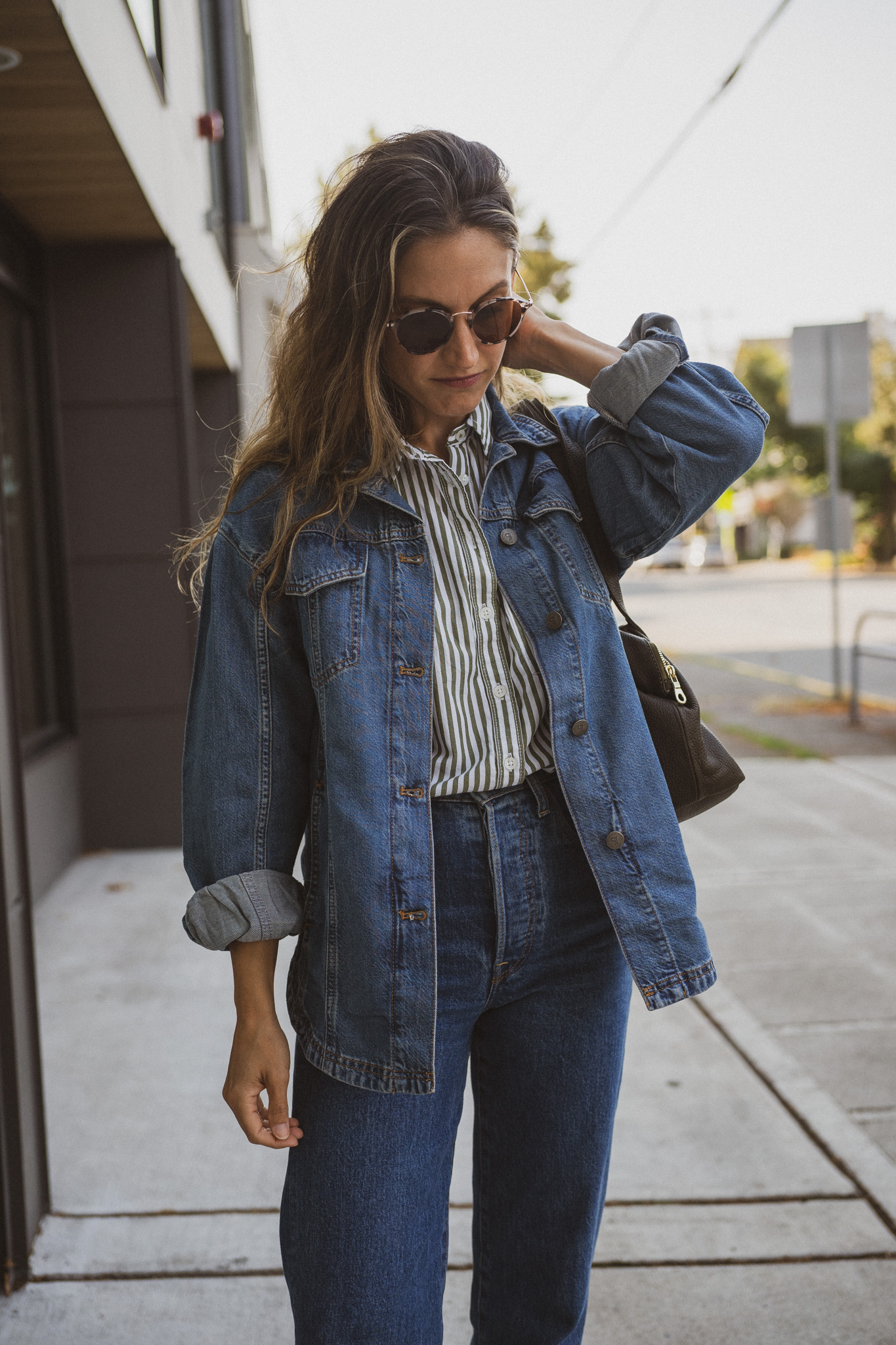 fall outfit idea with a striped button down, denim shirt jacket, medium wash denim, and brown loafers