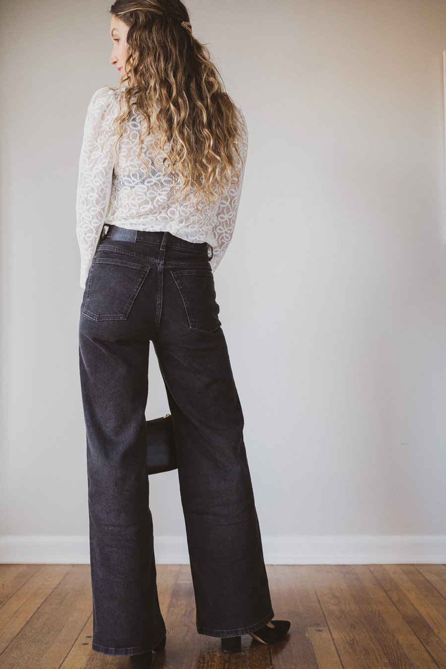 holiday look with a white lace top, black wide leg jeans, and black pumps