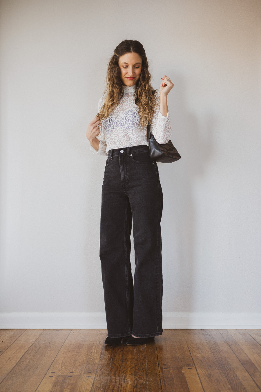 holiday look with a white lace top, black wide leg jeans, and black pumps