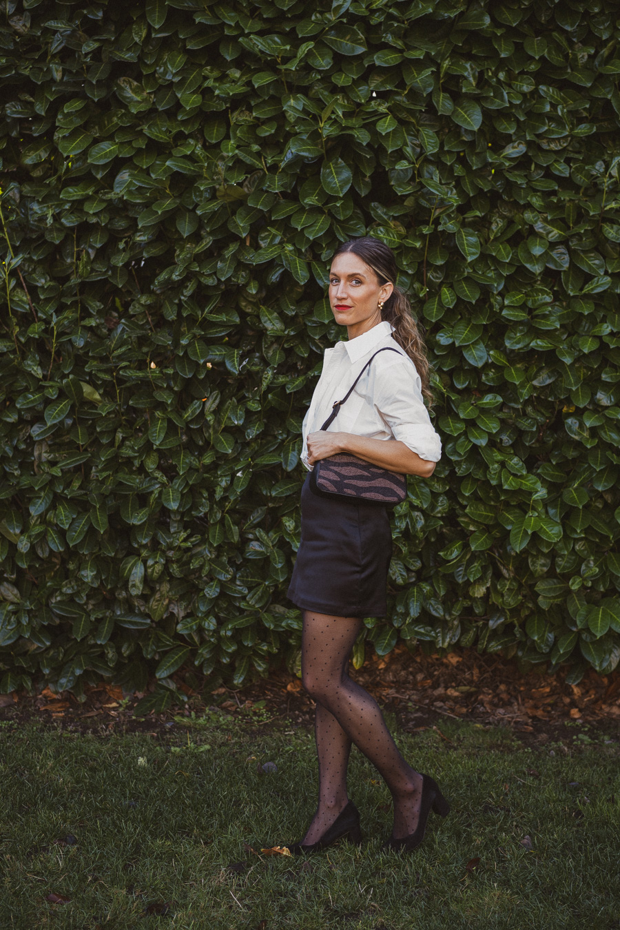 holiday look with a white button down, satin skirt, polka dot tights and black pumps
