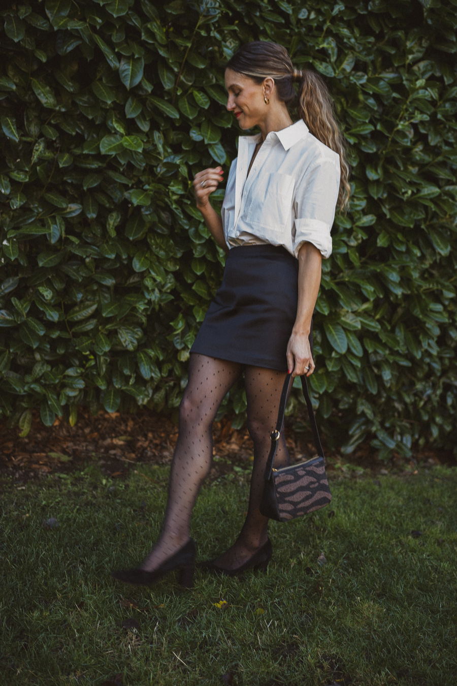 holiday look with a white button down, satin skirt, polka dot tights and black pumps