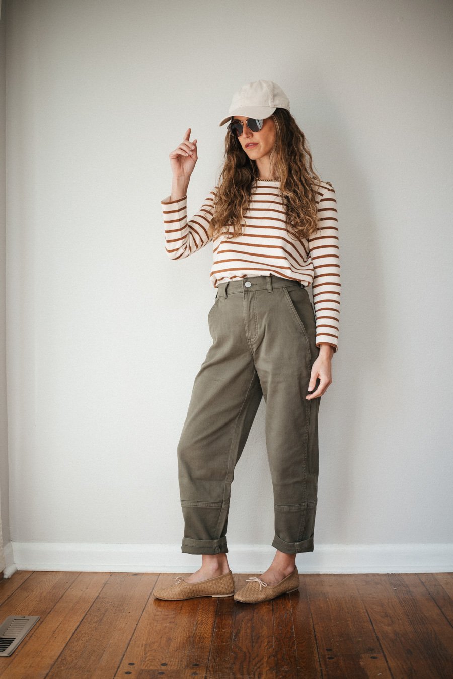 outfit with green cargo pants, a camel and ecru striped top, and nude woven ballet flats
