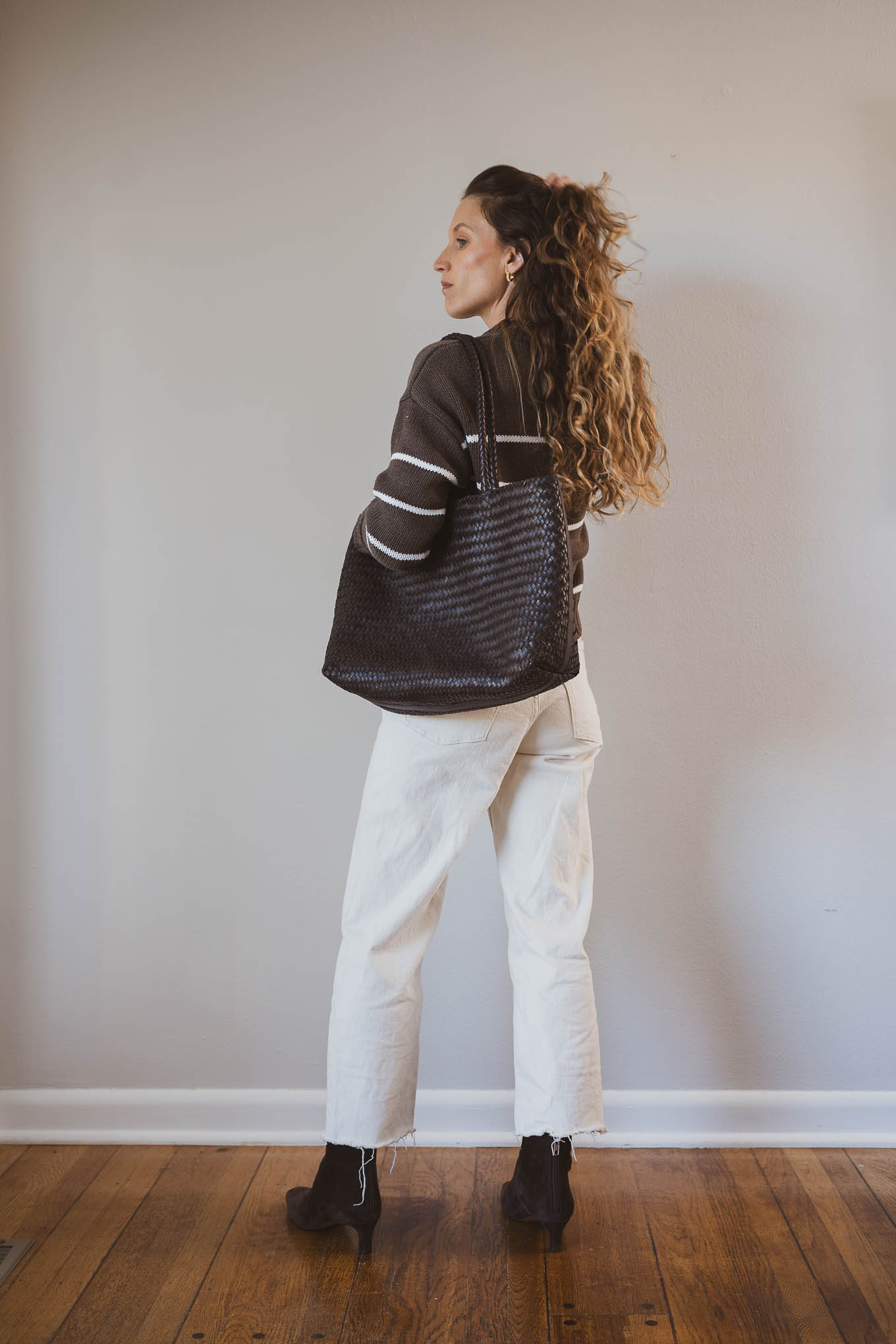 fall capsule outfit with a striped sweater, ecru jeans, and brown boots