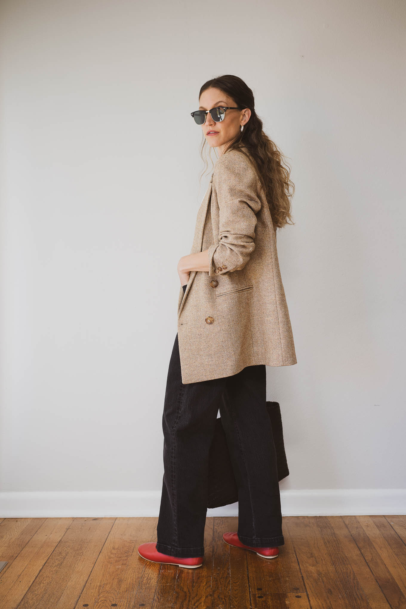 fall capsule wardrobe outfit with a white tee, tan wool blazer, black jeans, and red mary jane ballet flats