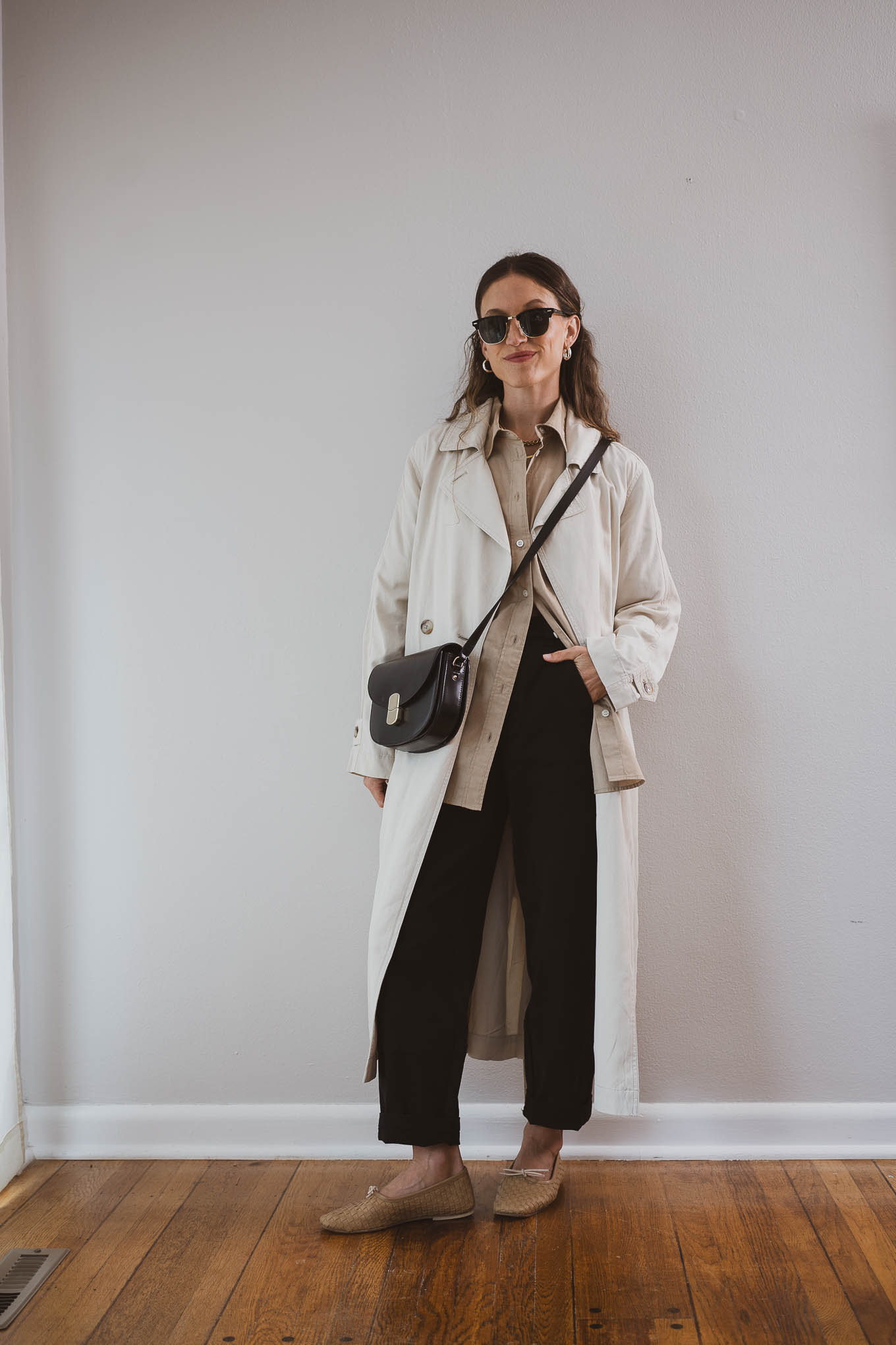 fall outfit idea with a tan button down, beige trench coat, black pants, and tan ballet flats