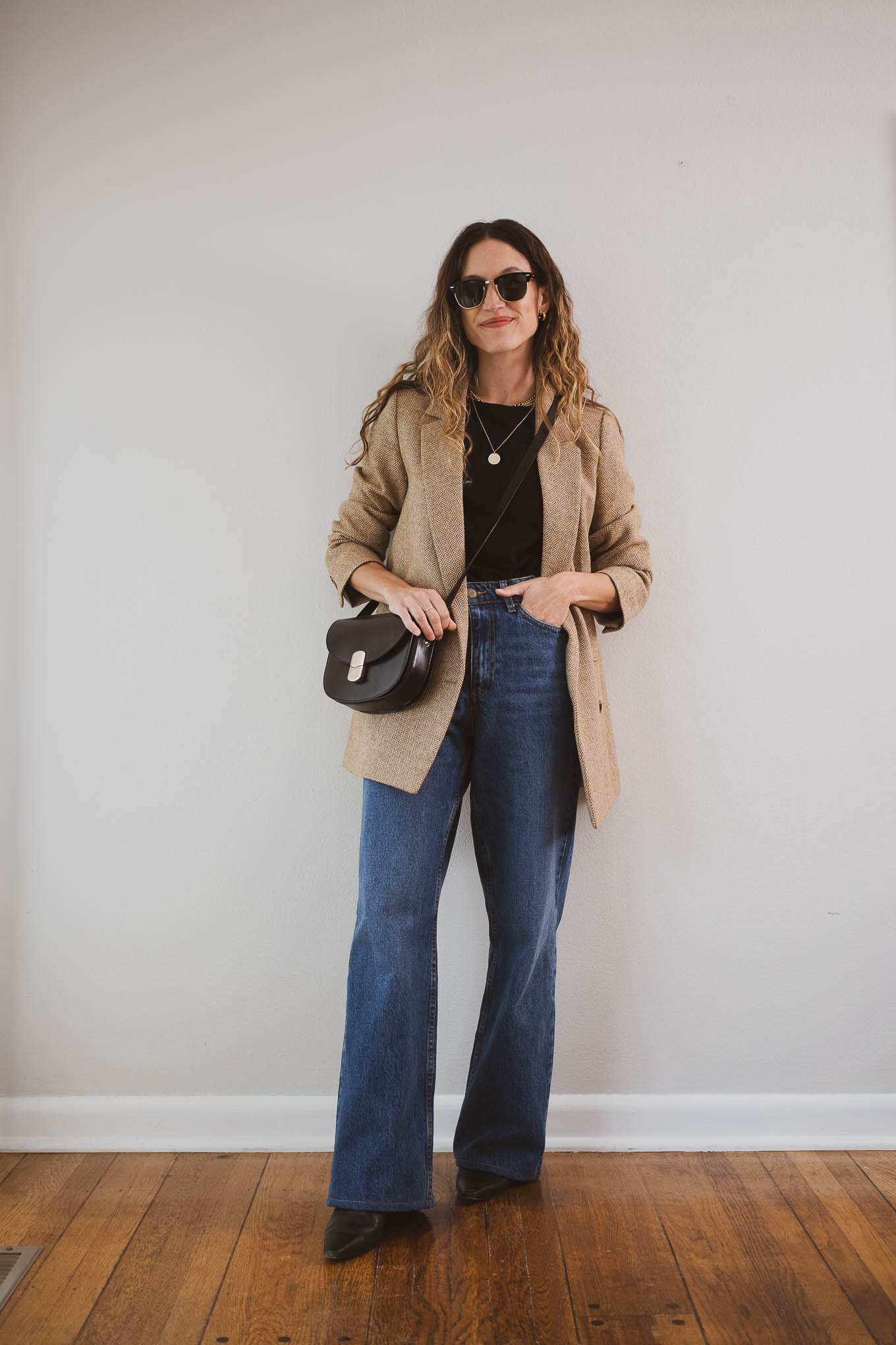 fall outfit idea with a black tee, tan herringbone blazer, wide leg jeans, and black boots
