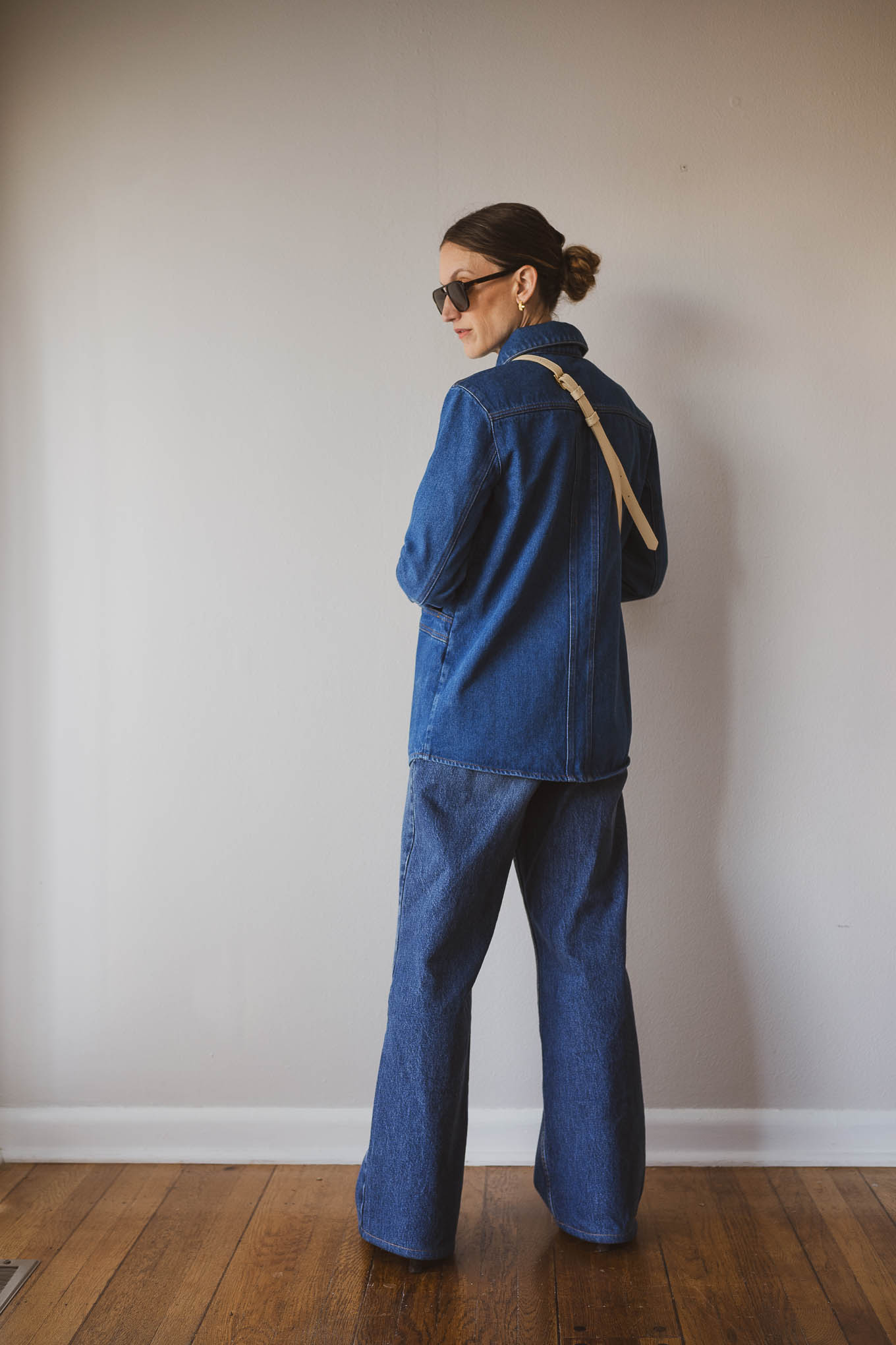 fall outfit idea with a cream fitted sweater, wide leg jeans, brown heeled ankle boots, and denim chore jacket
