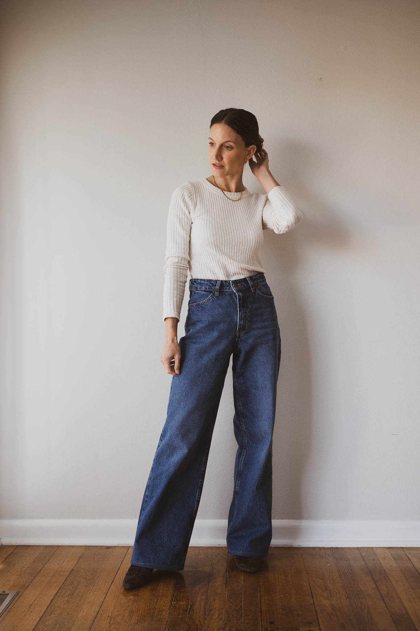 fall outfit idea with a cream fitted sweater, wide leg jeans, brown heeled ankle boots, and denim chore jacket
