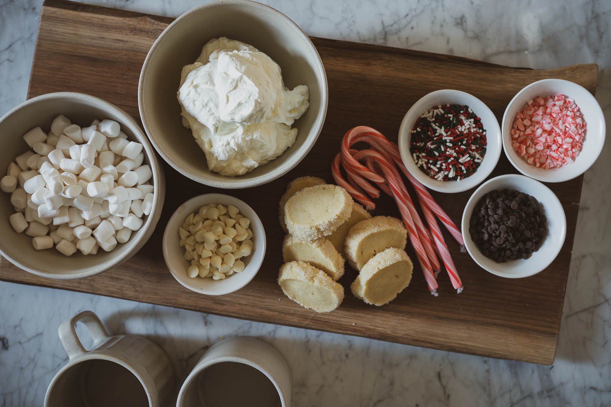 how to make an easy hot chocolate bar; hot chocolate bar toppings including candy canes, chocolate chips, whipped cream, marshmallows, and sprinkles