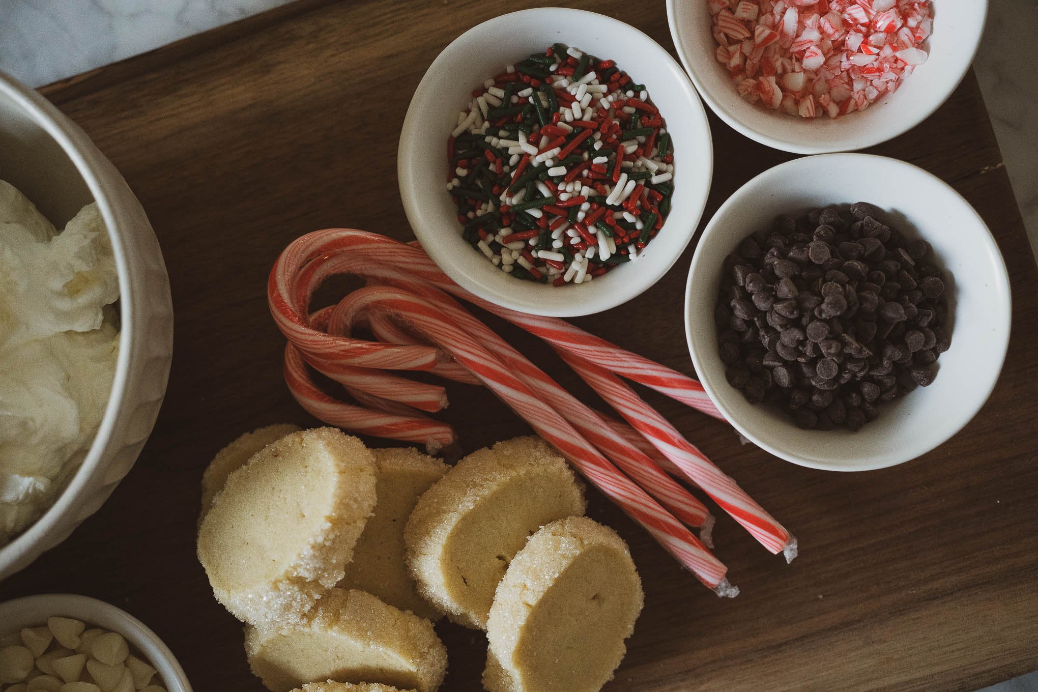 how to make an easy hot chocolate bar; hot chocolate bar toppings including candy canes, chocolate chips, whipped cream, marshmallows, and sprinkles