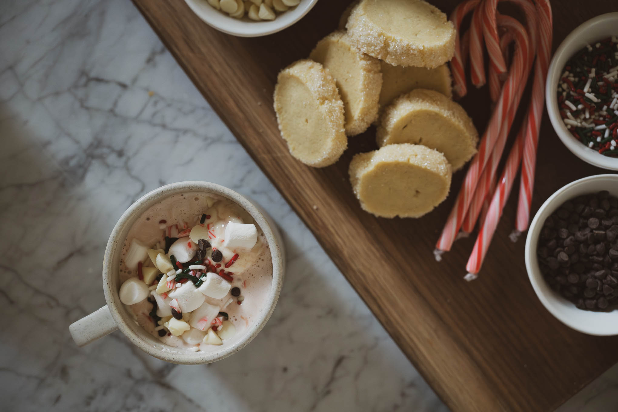 how to make an easy hot chocolate bar; hot chocolate bar toppings including candy canes, chocolate chips, whipped cream, marshmallows, and sprinkles