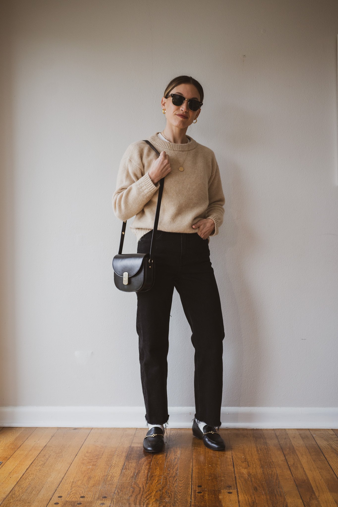 how to style loafers with a tan relaxed fit wool sweater, black jeans, off white socks, and loafers