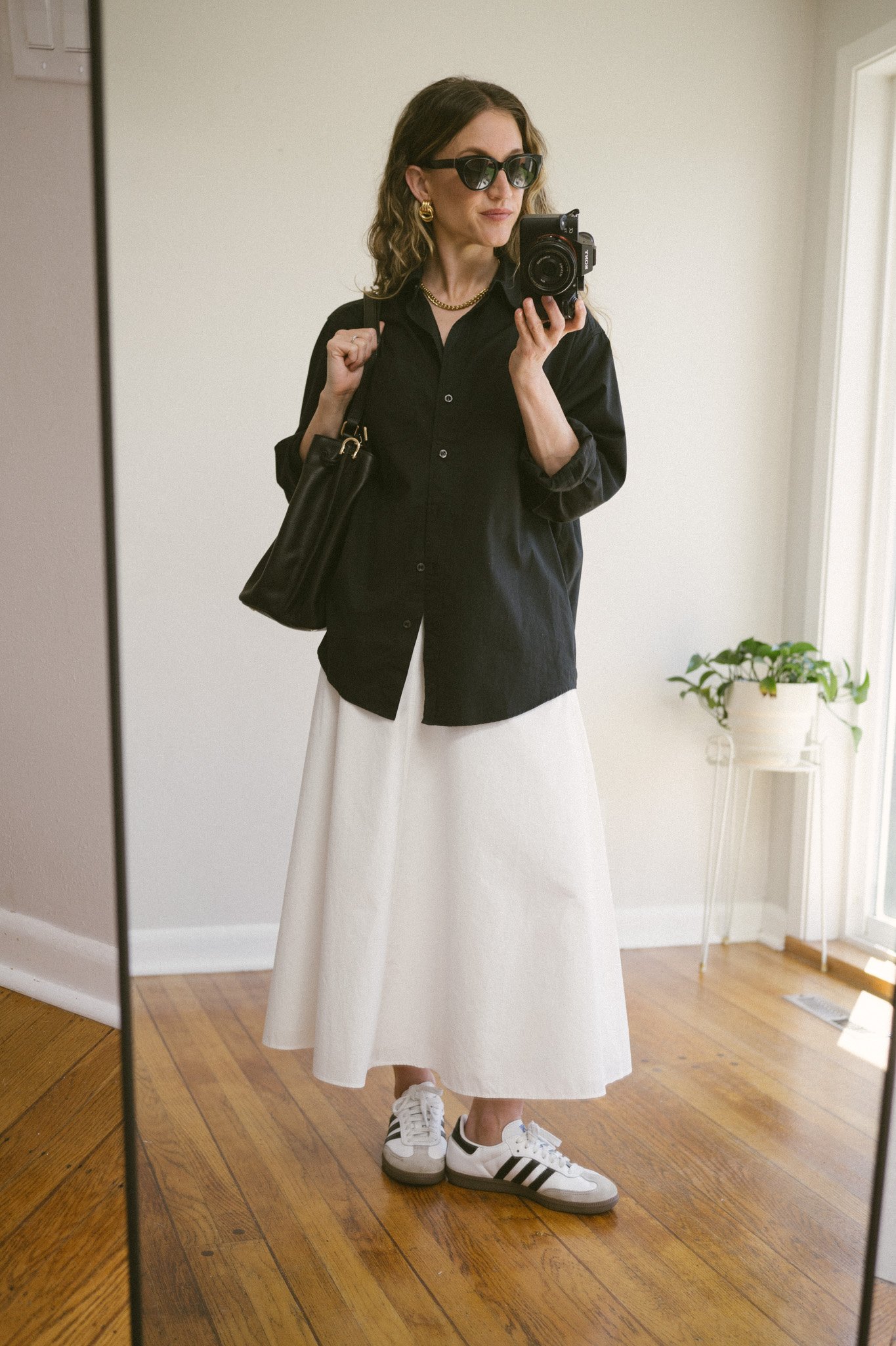 white poplin skirt outfit with a black button down, white skirt, and Adidas Sambas