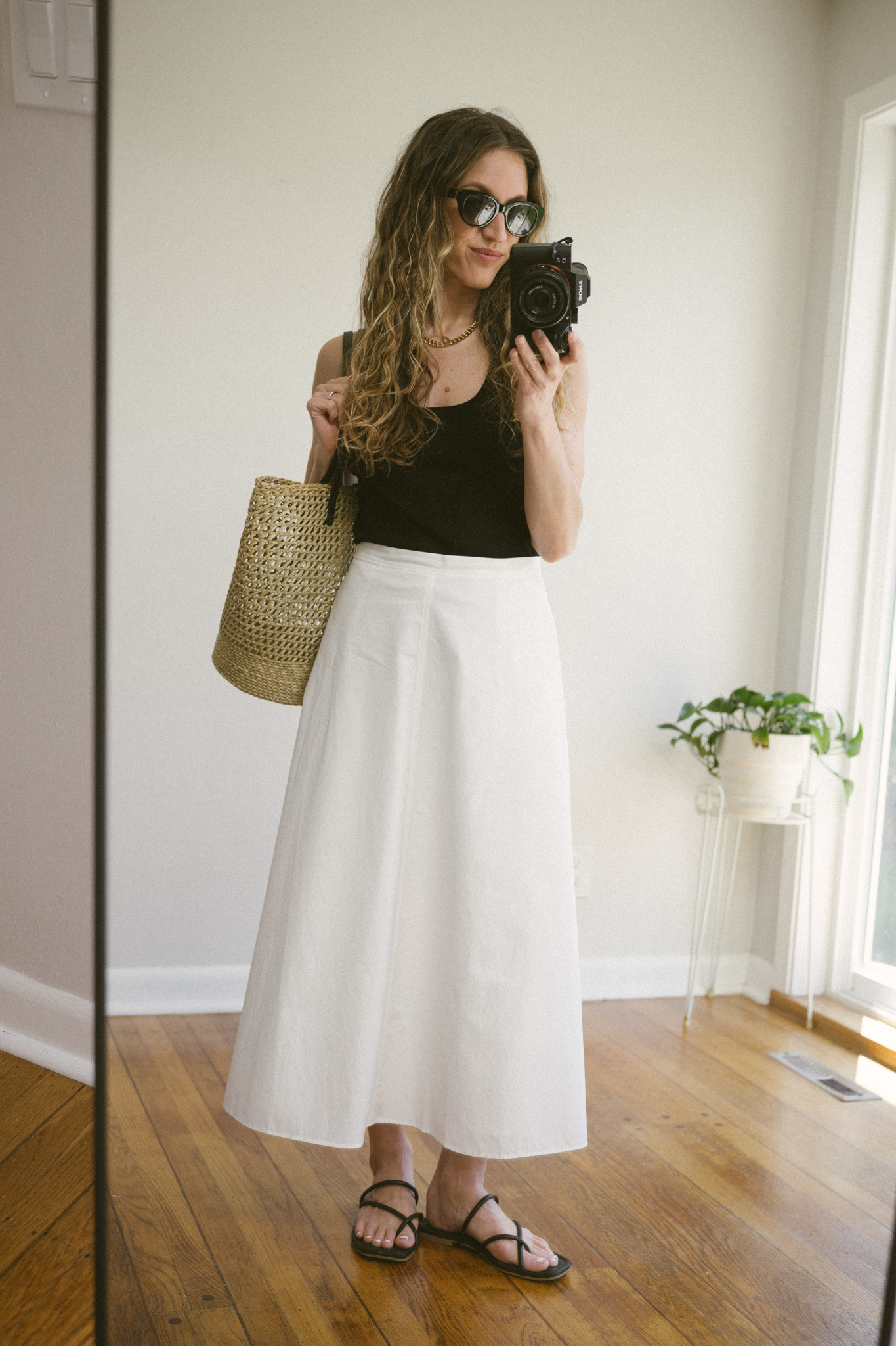 white poplin skirt outfit with a black tank, and sandals, and a basket bag