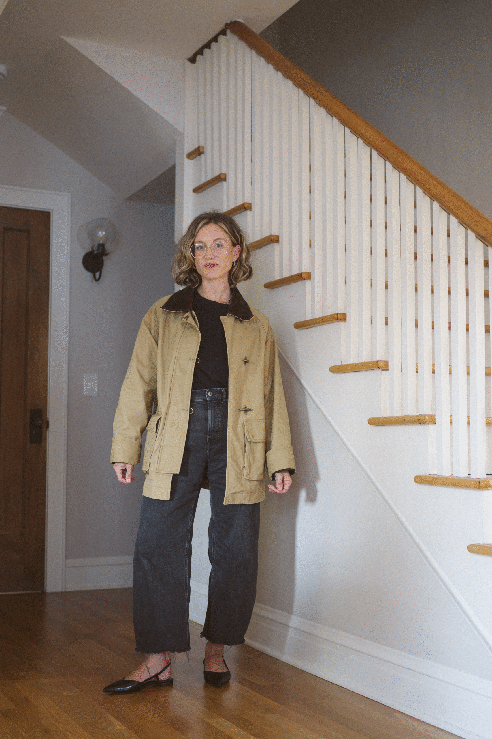 fall outfit with a black tee, black barrel jeans, black slingback flats, and a barn jacket