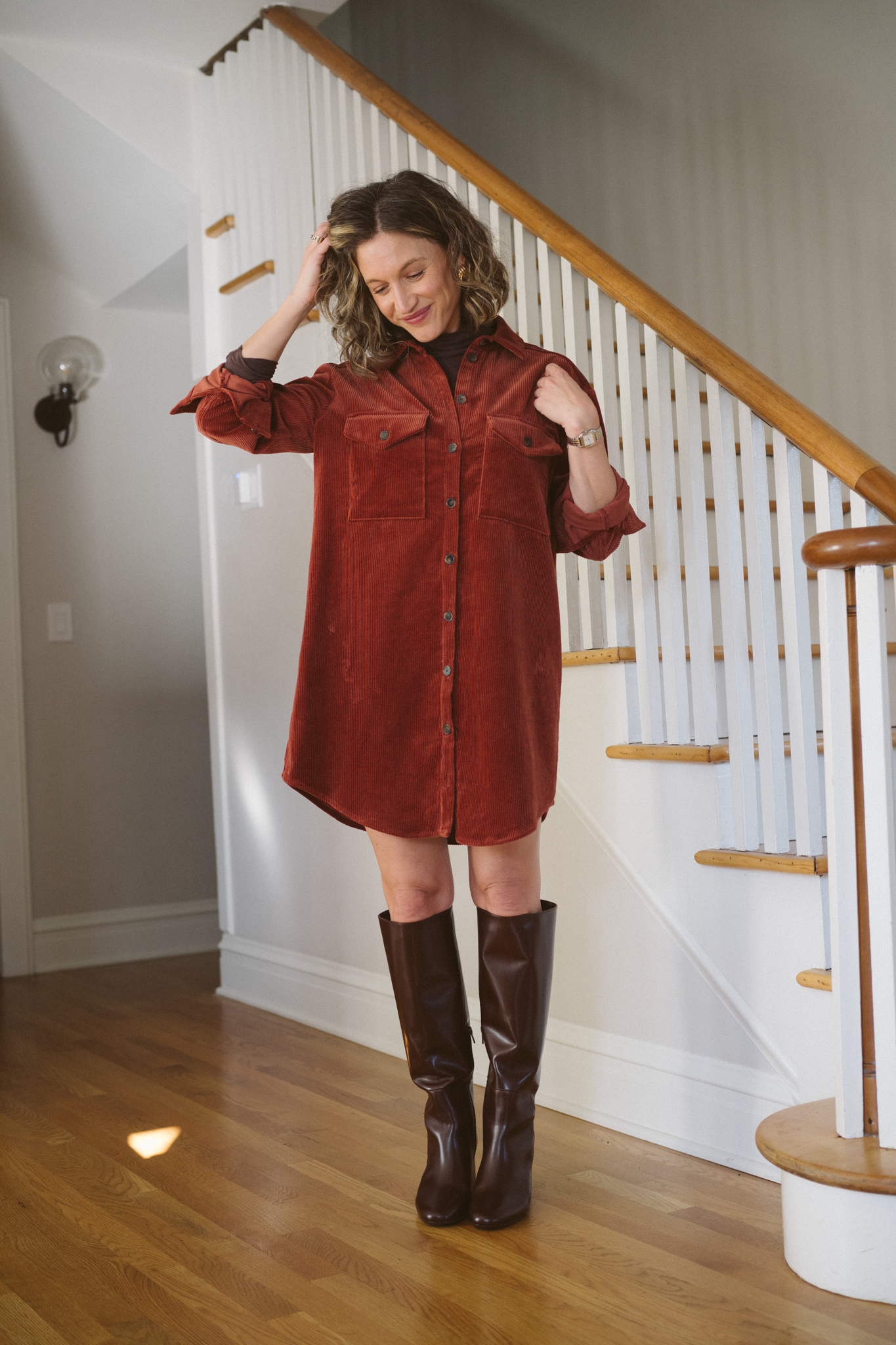 thanksgiving outfit with a rust colored corduroy shirt dress, brown turtleneck, and brown knee high boots